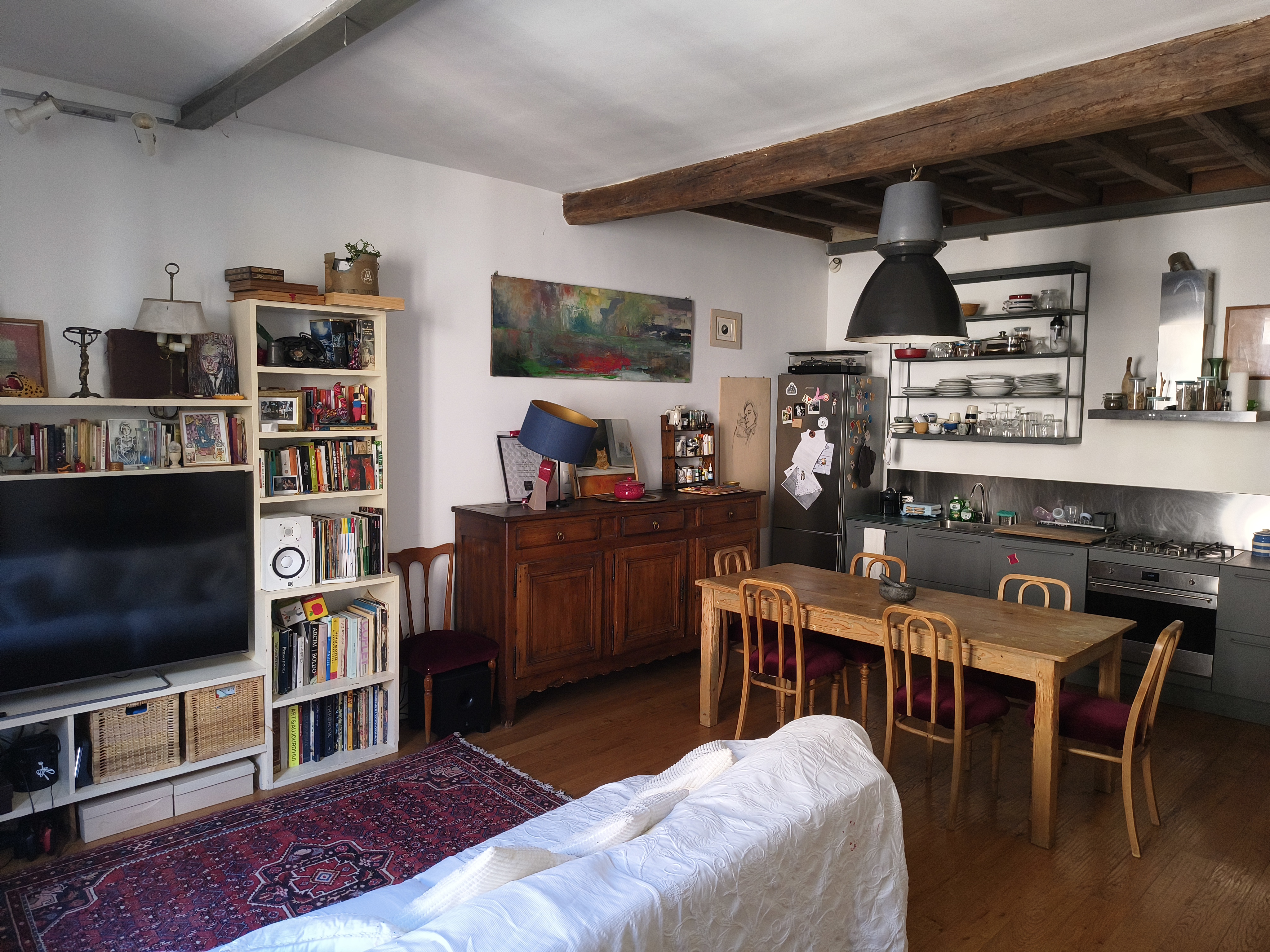 The large living room with bookshelves and dining table