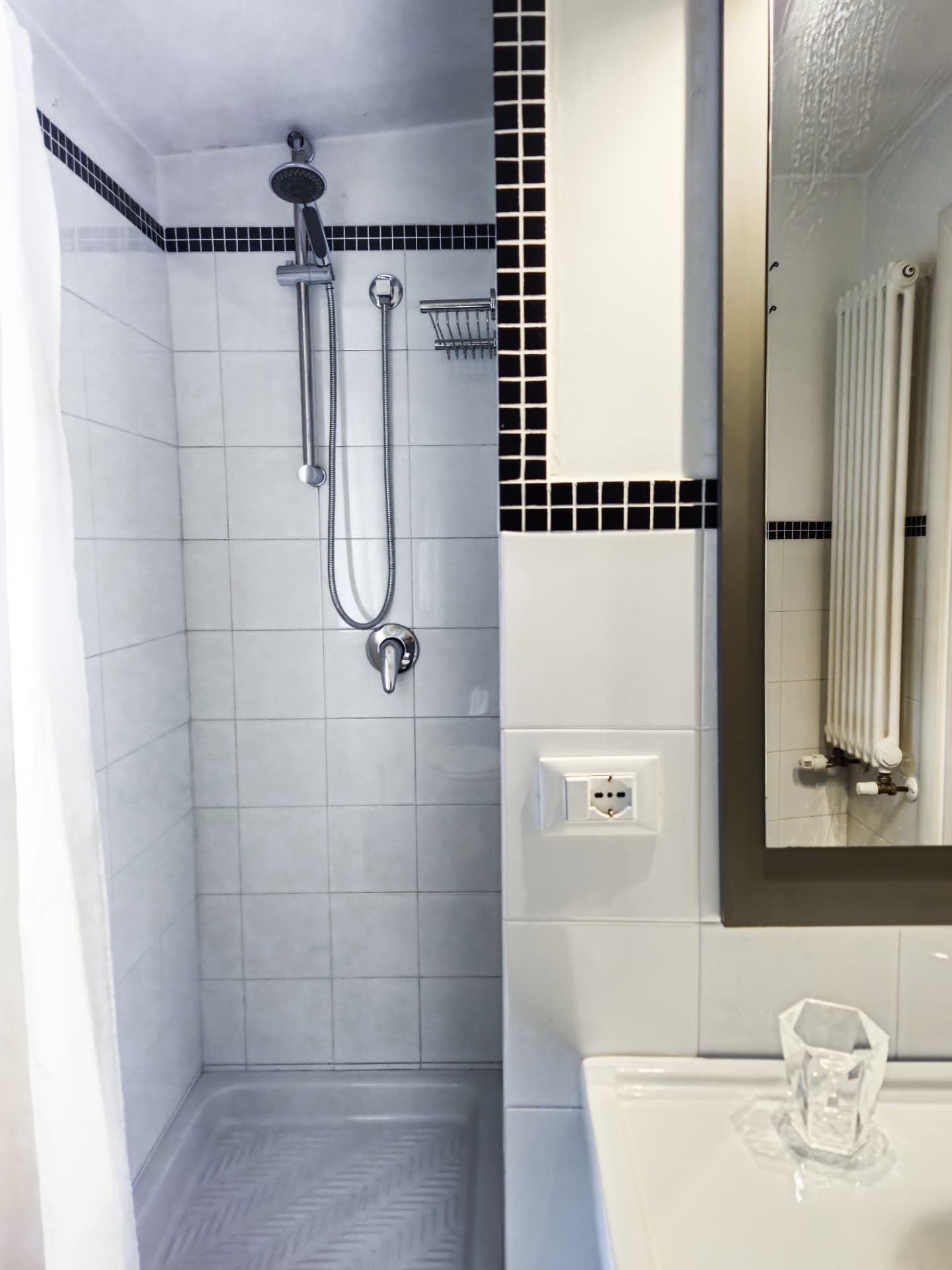 Bagno con doccia e rivestimento bianco